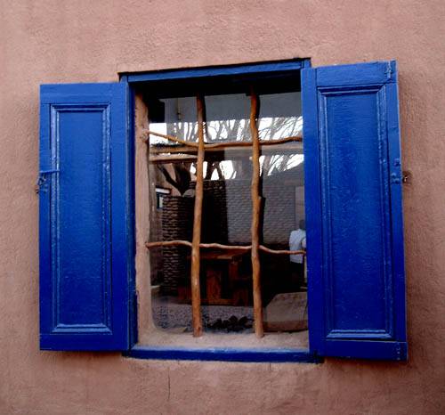 Typical blue window featuring tree branches in San Pedro de Atacama Chile
