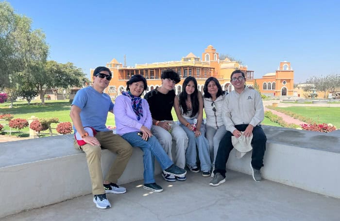 Family smiling in front of La Caravedo